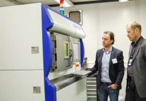 VTT on hyödyntänyt alkuvuodesta lähtien SLM Solutions metallien 3D-tulostinta. Kuvassa koneen lisäksi VTT:n tutkimusryhmän vetäjä Pasi Puukko (oik.) ja Vossi Groupin liiketoiminnan kehitysjohtaja Marko Vossi. 